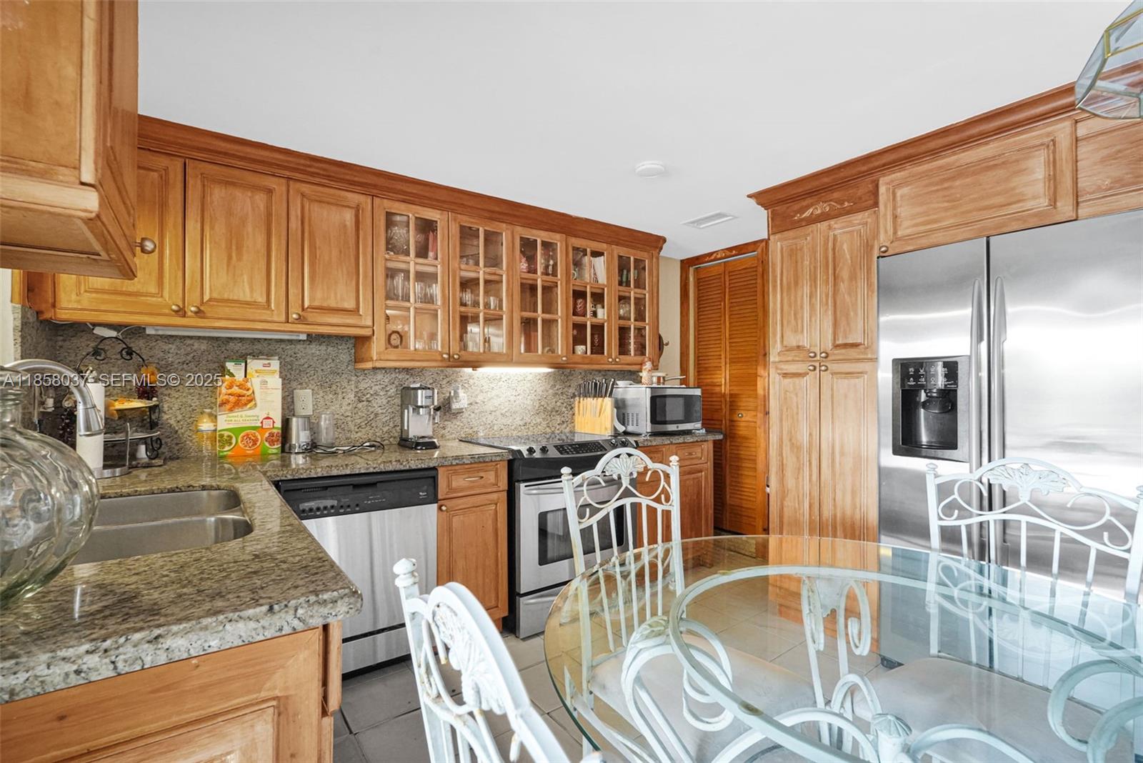 3711 Southwest 87th Avenue Miami, FL 33165 - Photo 36 of 92 a kitchen with stainless steel appliances granite countertop a stove a refrigerator a sink a dining table and chairs