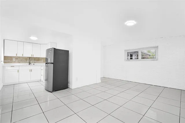 a kitchen with white cabinets and white appliances