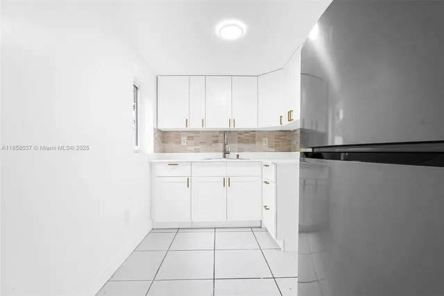 a kitchen with granite countertop white cabinets and sink
