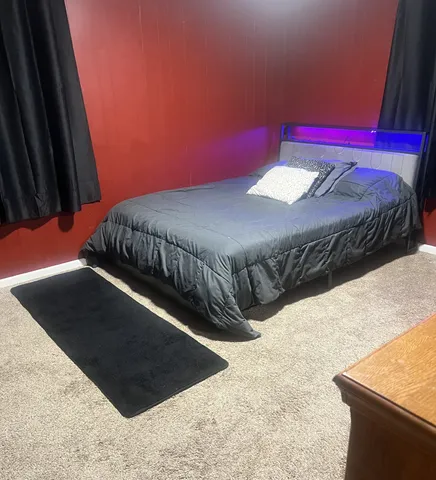 a bed sitting in a bedroom next to a larger window