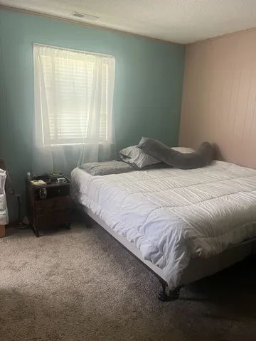 a bedroom with a bed lamp and window