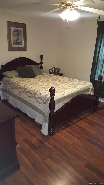 3220 Edwards Road Wingate, NC 28174 - Photo 13 of 21 a bedroom with a bed and wooden floor