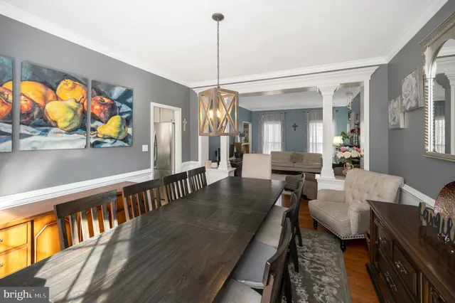 a dining room with furniture a floor to ceiling window and wooden floor