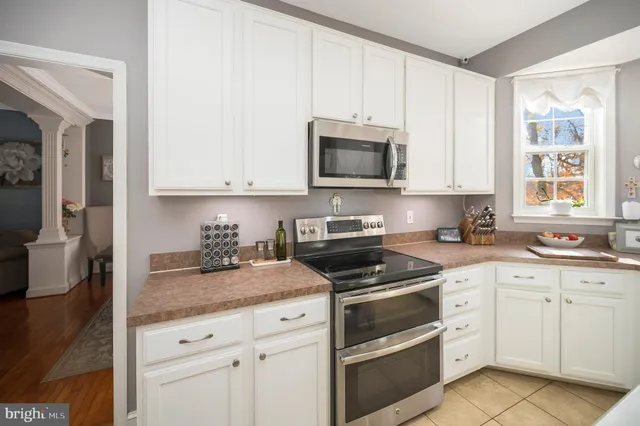 a kitchen with granite countertop white cabinets white stainless steel appliances and a sink