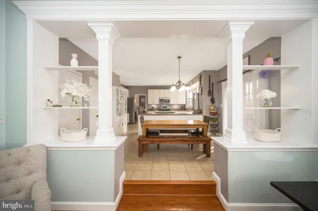 a room with stainless steel appliances kitchen island granite countertop furniture and a view of living room