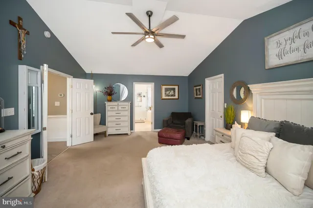 a bedroom with a bed a ceiling fan and a couch