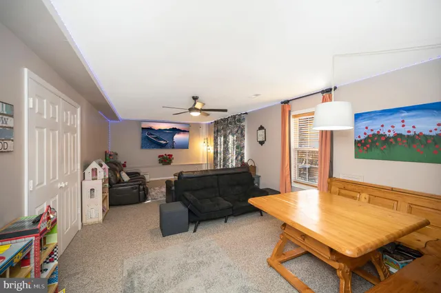 a living room with furniture a flat screen tv and paintings on the wall