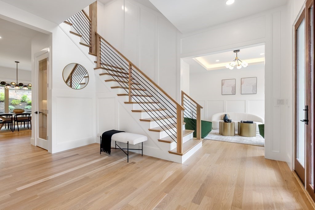 a view of front door with hallway and wooden floor