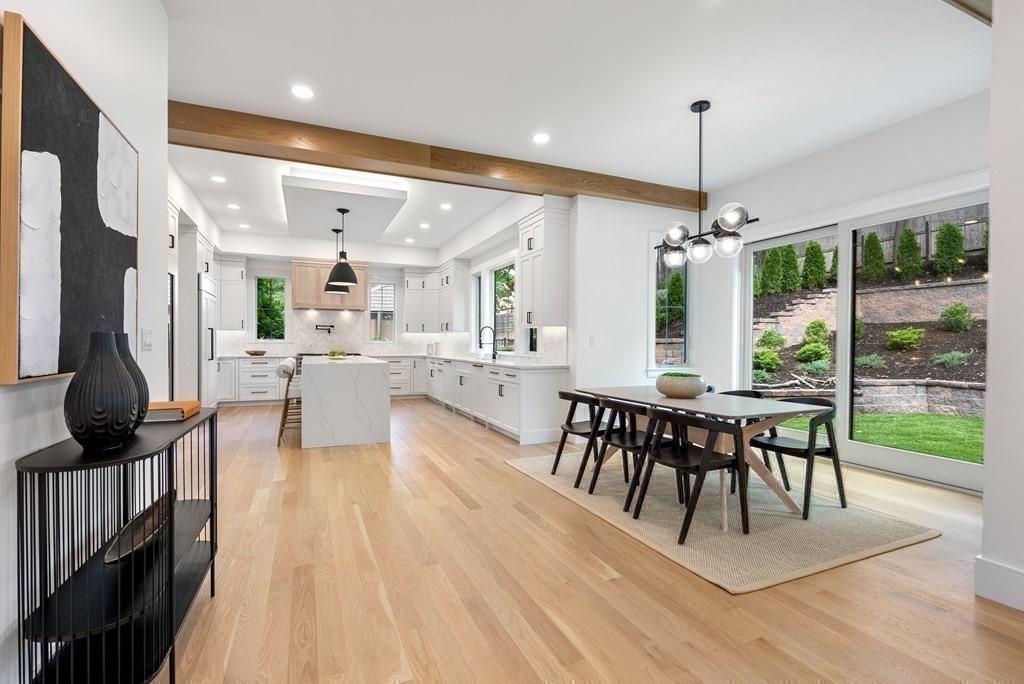 91 Oldham Road Newton, MA 02465 - Photo 11 of 38 a view of a dining room and livingroom with furniture wooden floor a chandelier