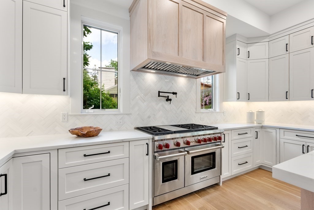 91 Oldham Road Newton, MA 02465 - Photo 9 of 38 a kitchen with stainless steel appliances a stove and white cabinets