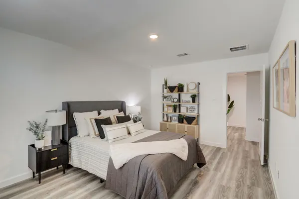 a bedroom with a bed and wooden floor