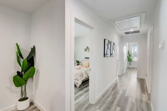 a view of a hallway to a livingroom with wooden floor