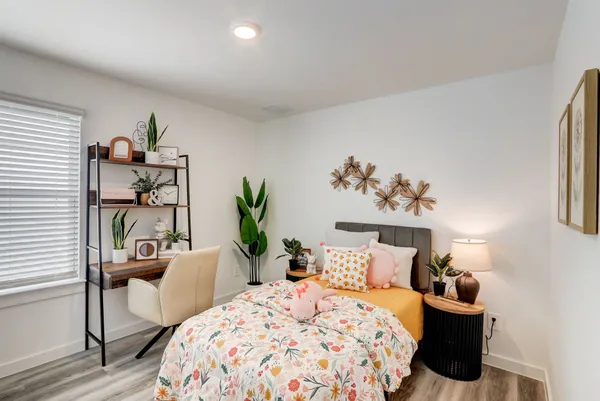 a bedroom with a bed and a potted plant
