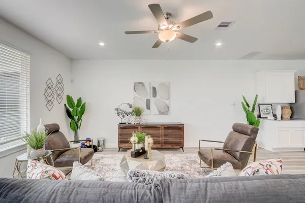 a living room with furniture chandelier and a potted plant