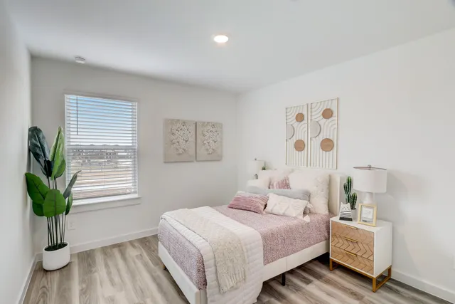 a bedroom with a bed and a potted plant