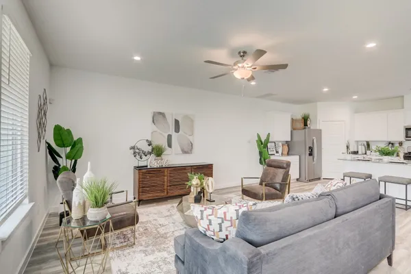 a living room with furniture flowerpot and a chandelier