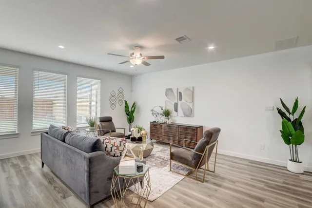 a living room with furniture potted plant and window