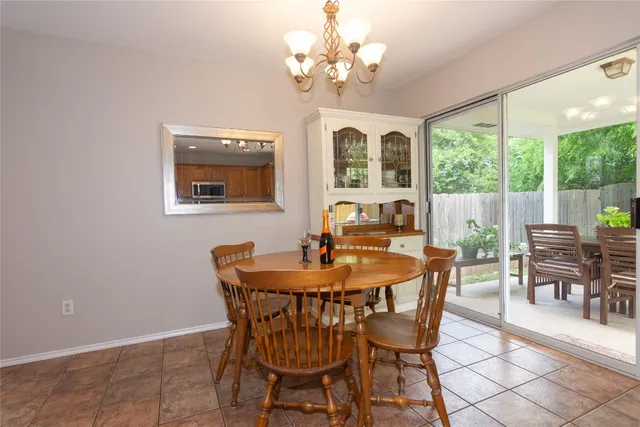 a dining room with furniture a large window and a chandelier