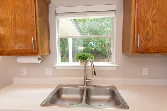 a kitchen with a sink a window and cabinets