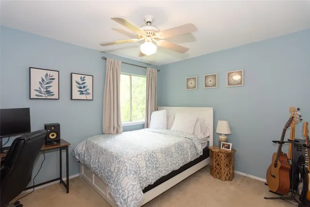 a bedroom with a bed and a ceiling fan