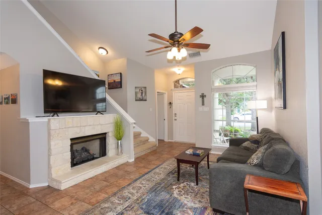 a living room with furniture a flat screen tv and a fireplace