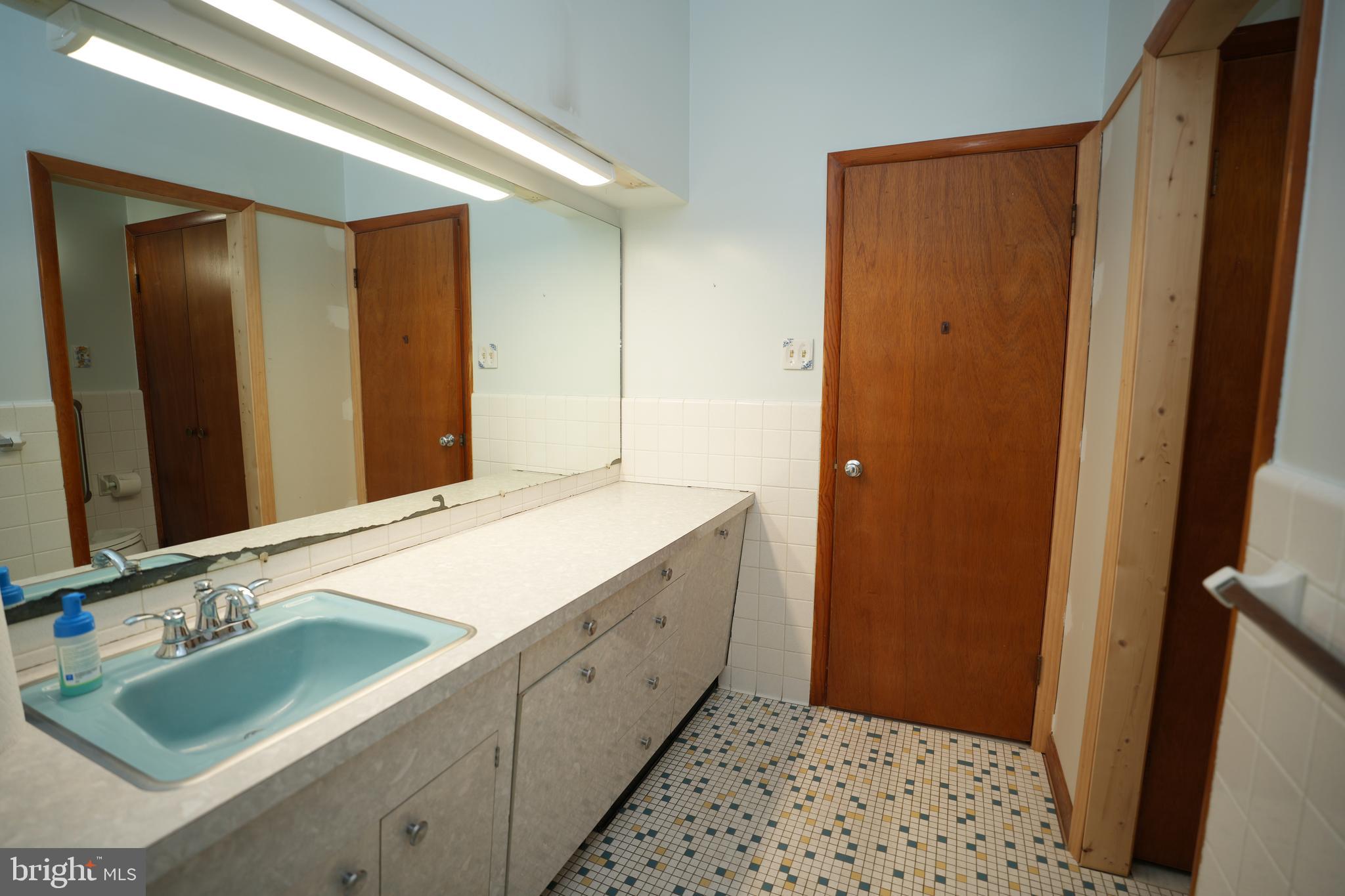 48607 Deep Cove Lane Ridge, MD 20680 - Photo 29 of 47 a bathroom with a double vanity sink and a mirror