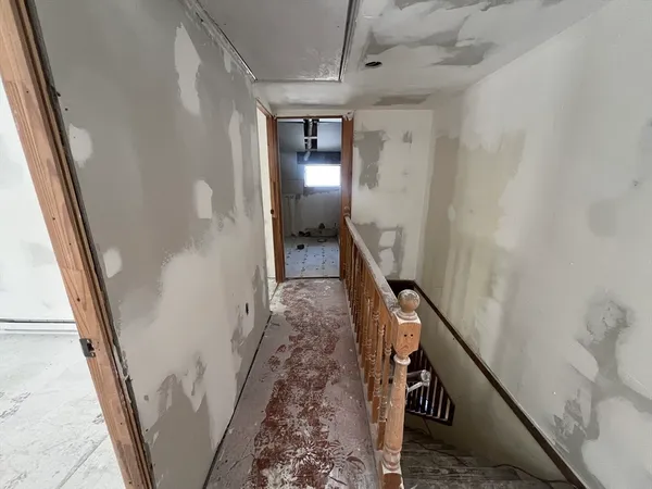 a view of a hallway with wooden floor and stairs