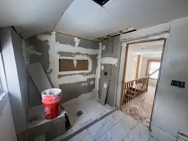 a hallway with wooden floor and stairs
