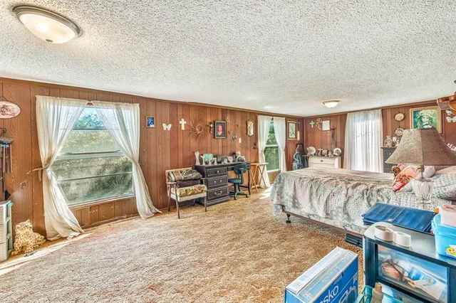 a bedroom with furniture and a large window