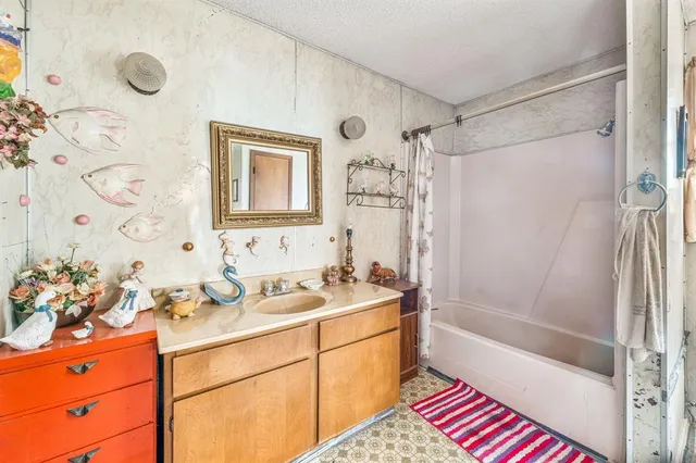 a bathroom with a sink a mirror a bathtub and shower