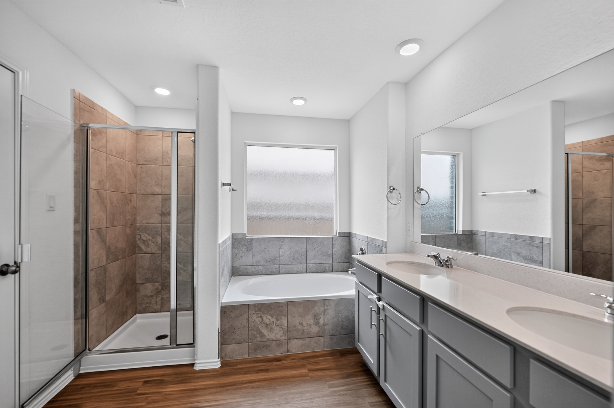 128 Konik Road Georgetown, TX 78626 - Photo 17 of 34 A pristine bathroom features a spacious soaking tub, separate shower, and a broad vanity with dual sinks.