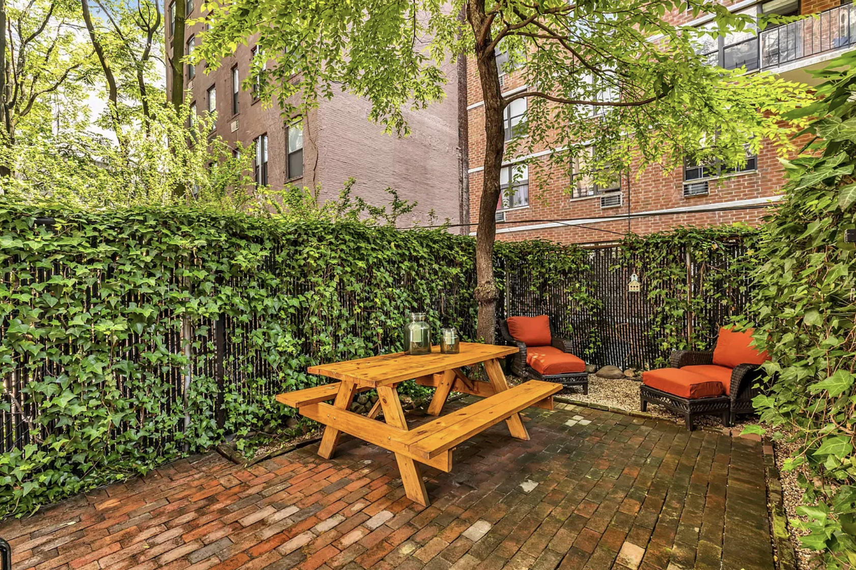 424 East 77th Street, Unit 1D Manhattan, NY 10075 - Photo 1 of 8 a backyard of a house with table and chairs