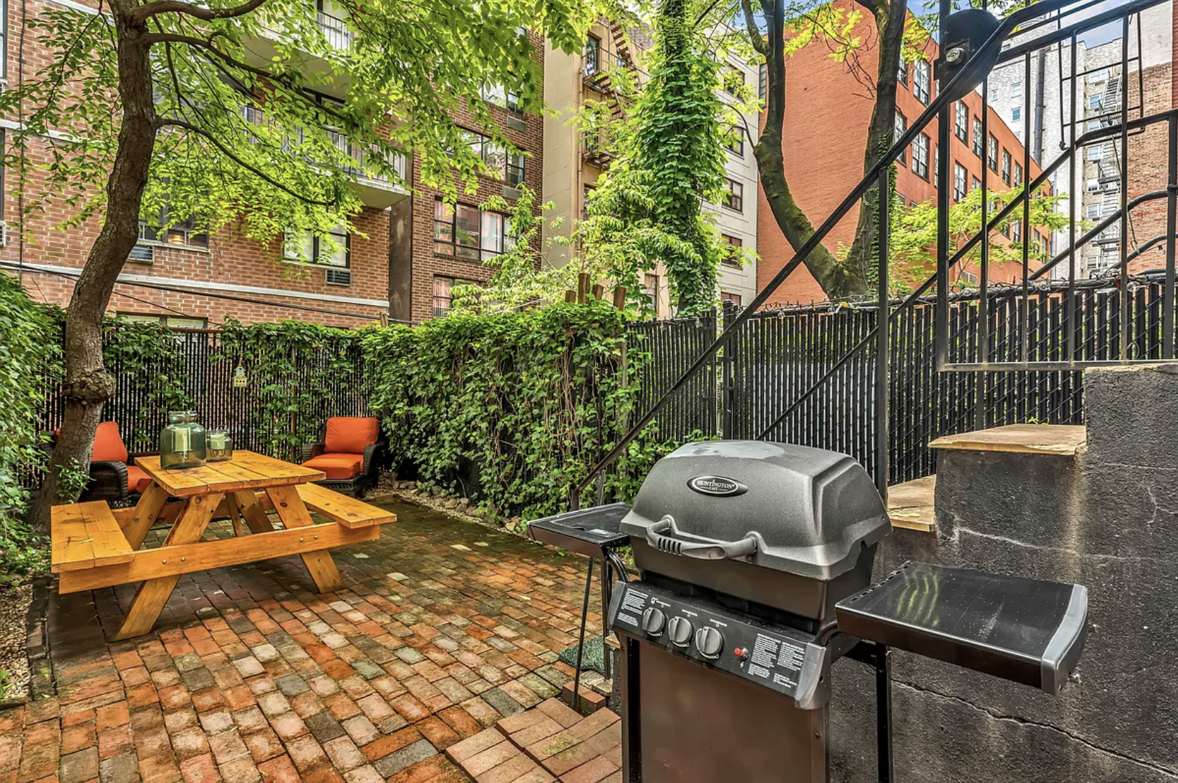 424 East 77th Street, Unit 1D Manhattan, NY 10075 - Photo 4 of 8 a backyard of a house with table and chairs