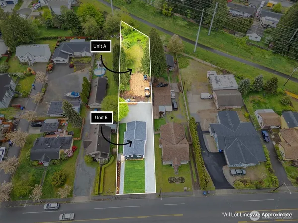 an aerial view of residential houses with outdoor space and parking
