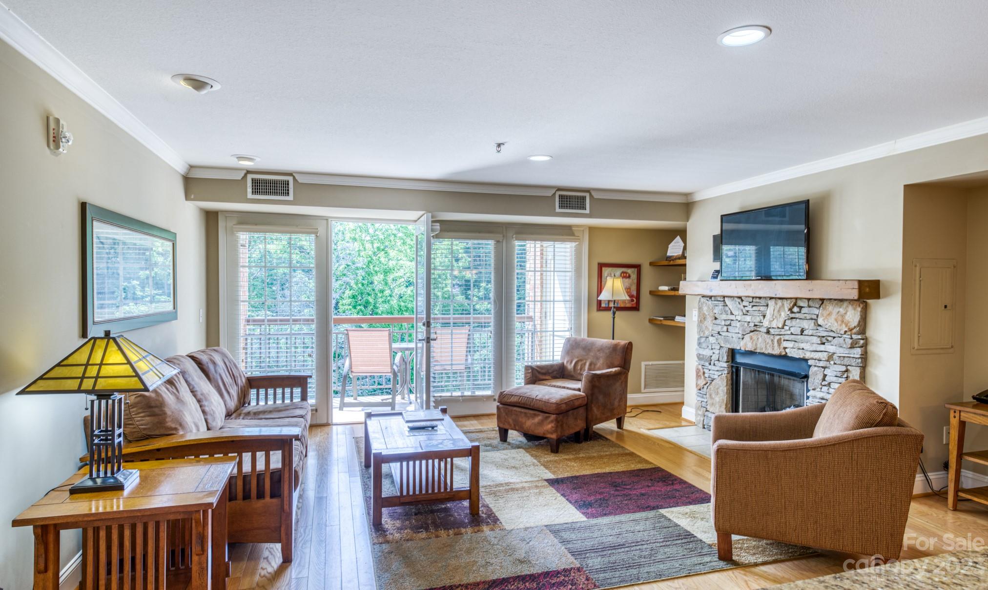 310 Bowling Park Road Asheville, NC 28803 - Photo 7 of 31 a living room with furniture a fireplace and a flat screen tv