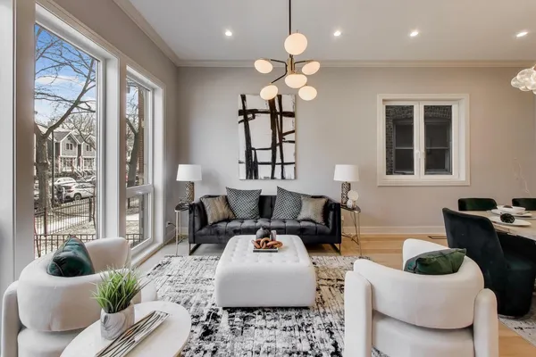 a living room with furniture chandelier and a large window