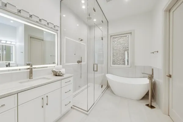a spacious bathroom with double vanity sink a mirror and a bathtub