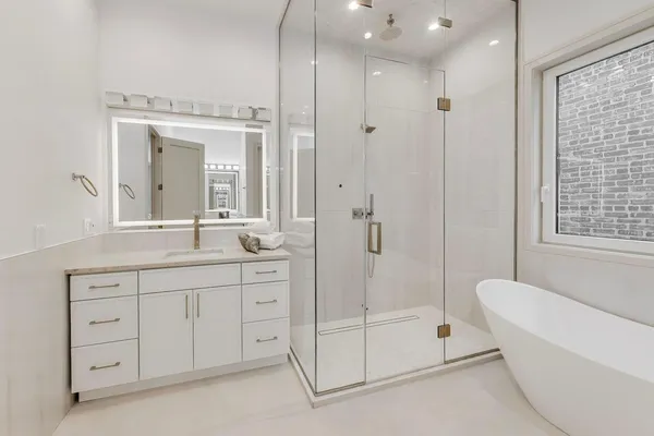 a bathroom with a shower a sink and a mirror