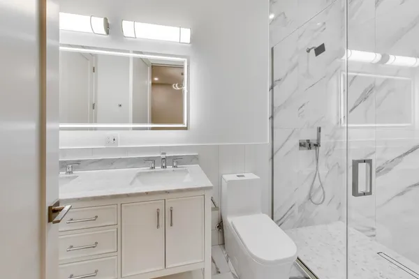 a bathroom with a sink vanity mirror and toilet