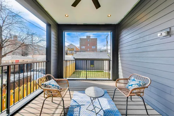 a balcony with chairs and with potted plants