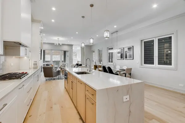 a large kitchen with stainless steel appliances a large counter top a stove a chimney a sink and a refrigerator