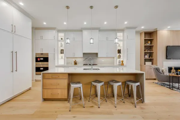 a large kitchen with granite countertop a table and chairs in it