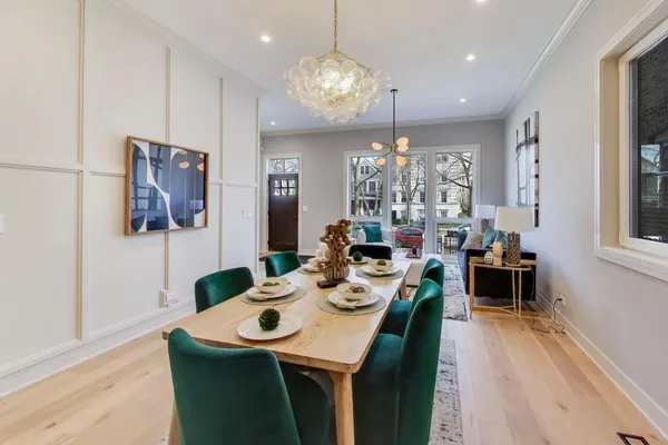 a view of a dining room with furniture a chandelier and wooden floor