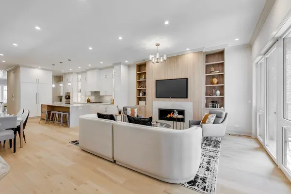 a living room with furniture a flat screen tv and kitchen view