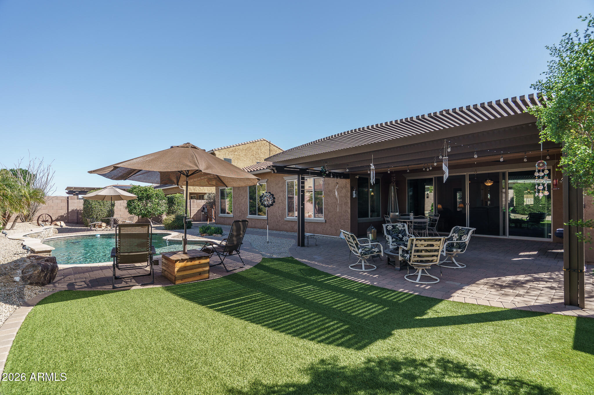18398 West Rimrock Street Surprise, AZ 85388 - Photo 31 of 65 a view of a backyard with table and chairs under an umbrella