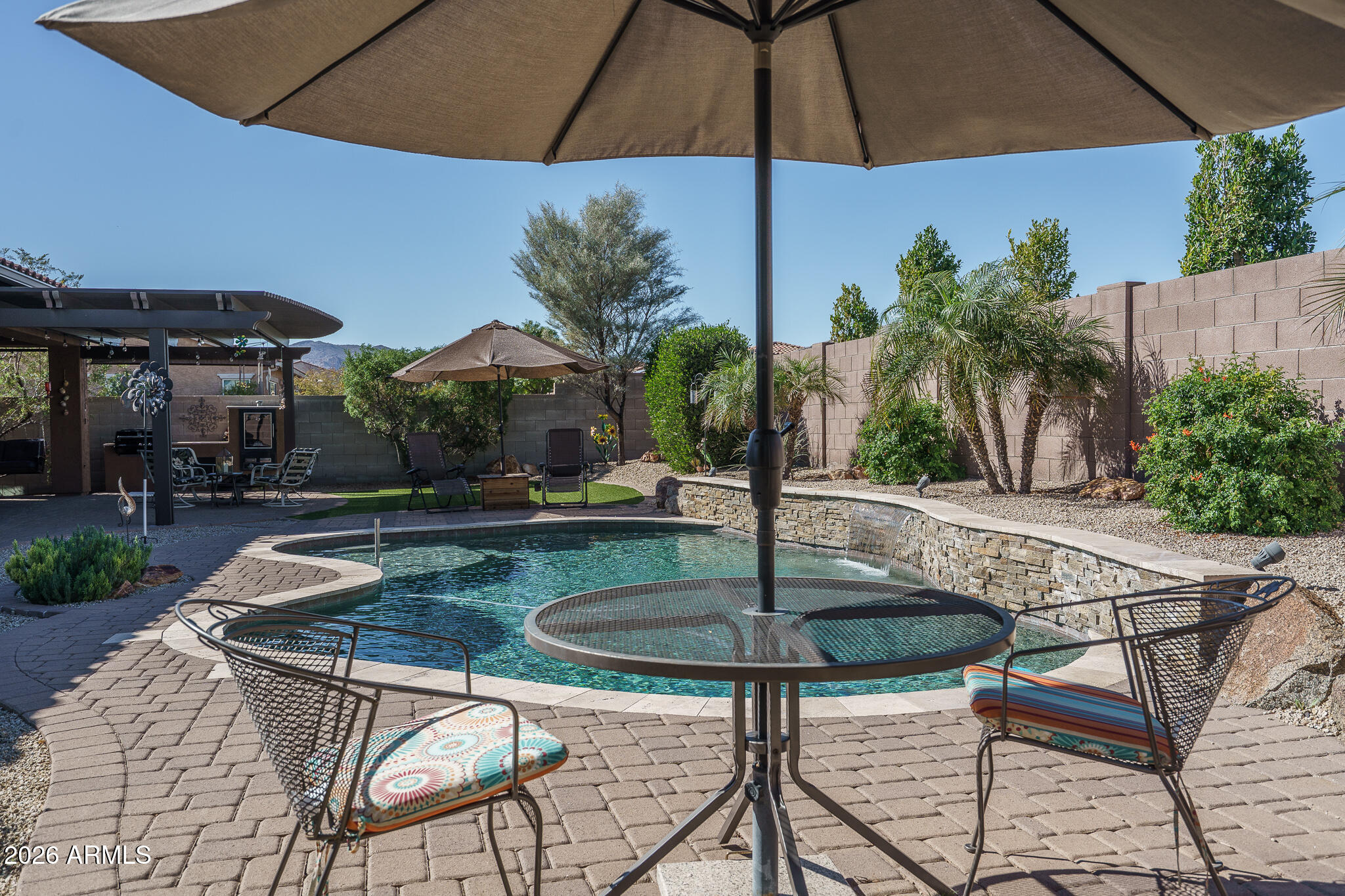 18398 West Rimrock Street Surprise, AZ 85388 - Photo 43 of 65 a patio with a table and chairs under an umbrella