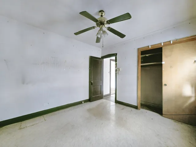 an empty room with closet and fan