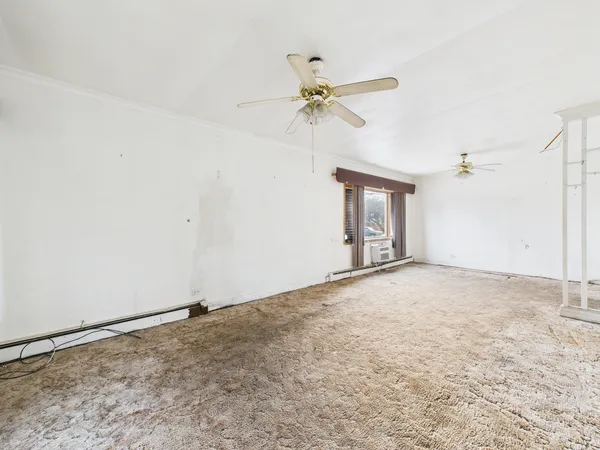 an empty room with windows and fan