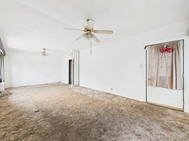 an empty room with closet and a chandelier fan