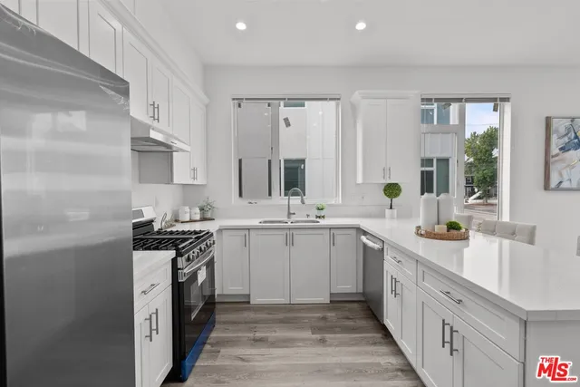 a kitchen with stainless steel appliances granite countertop a sink stove and refrigerator